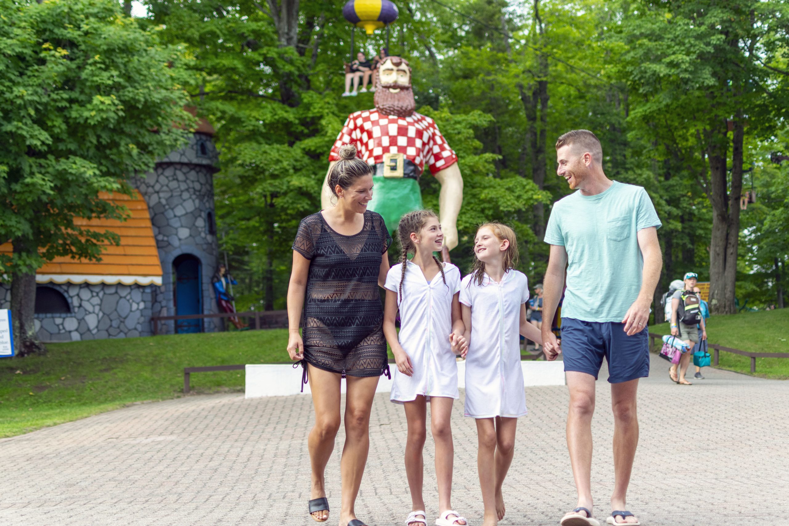 A family smiling and walking outside at Enchanted Forest Water Safari.